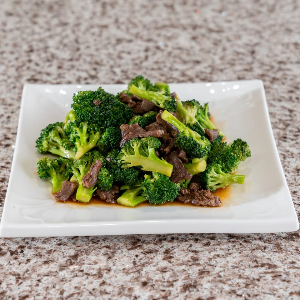 Beef and broccoli on a white plate.