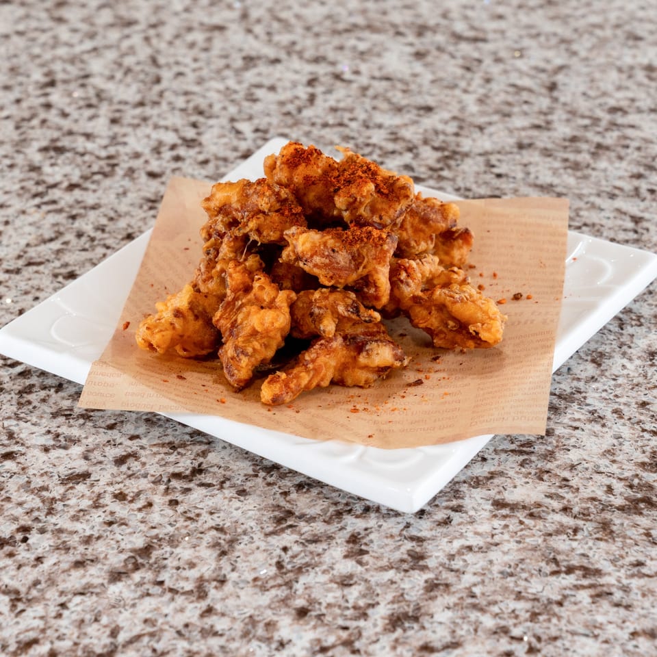 Seasoned crispy fried bites on a white plate.