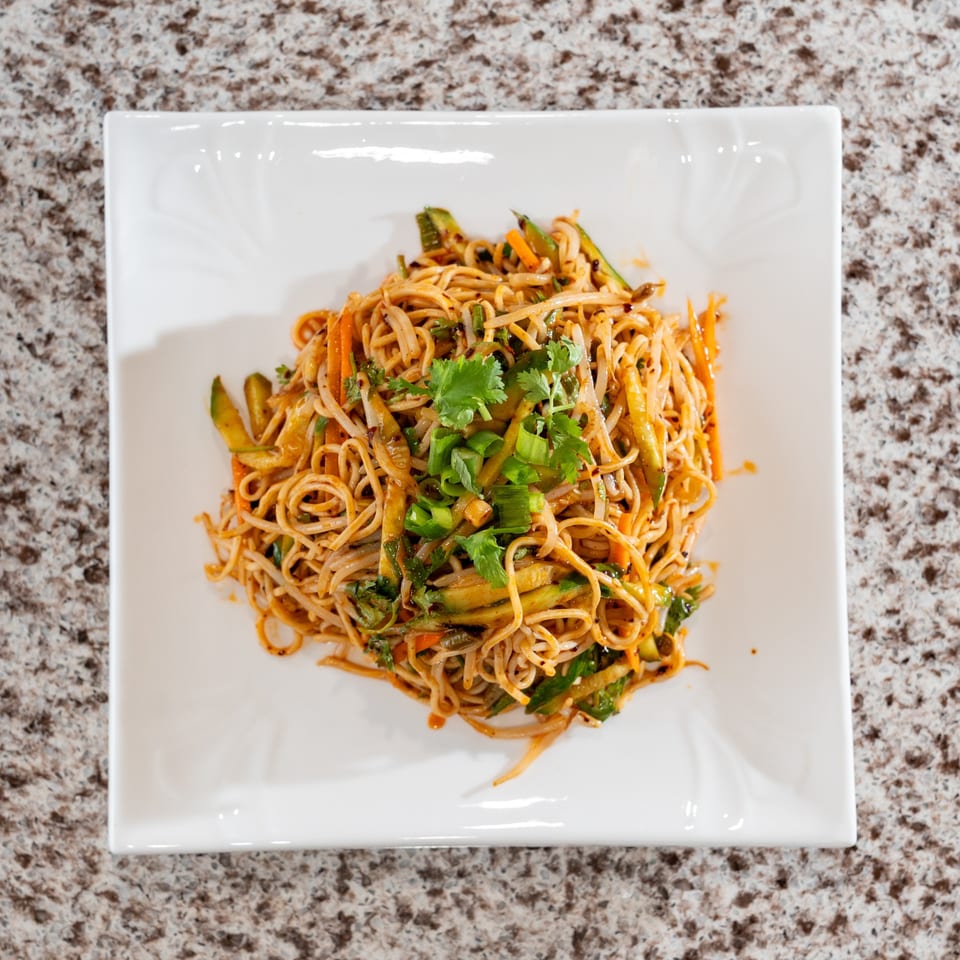 Noodles with vegetables and fresh herbs.