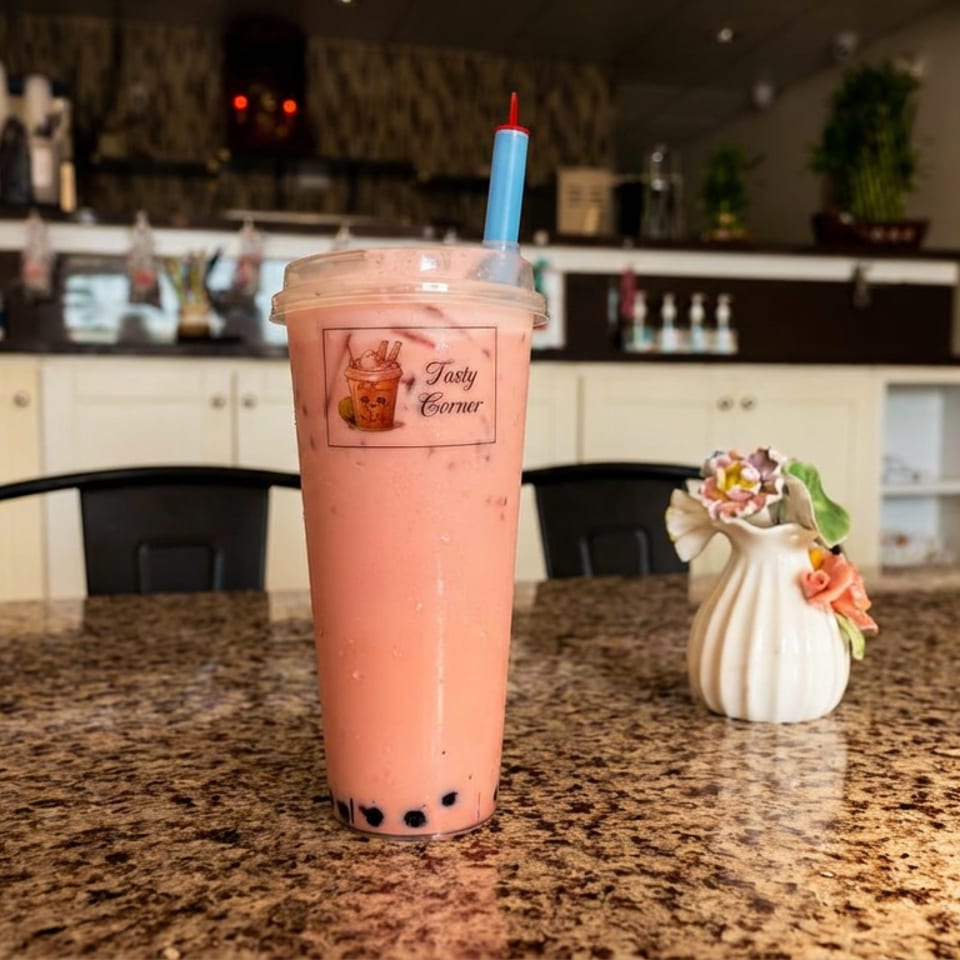 Pink strawberry bubble tea with tapioca pearls on a granite table inside Tasty Corner café.