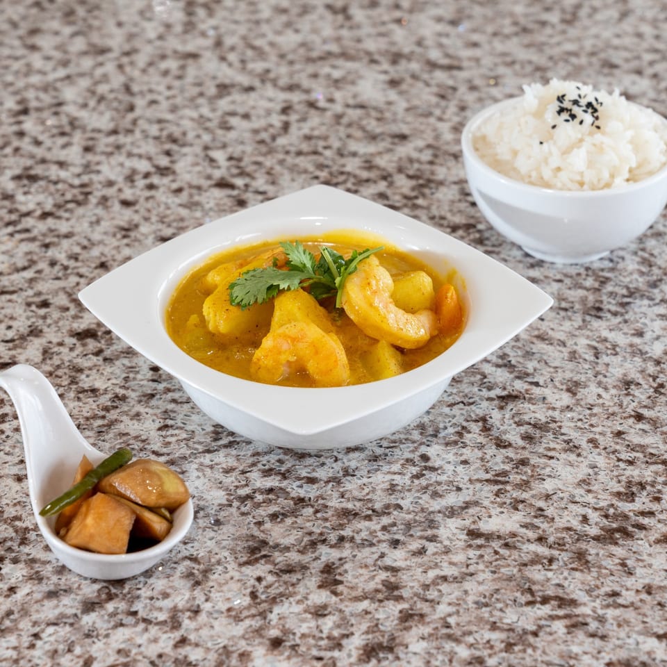 Shrimp curry served with rice and pickled vegetables.